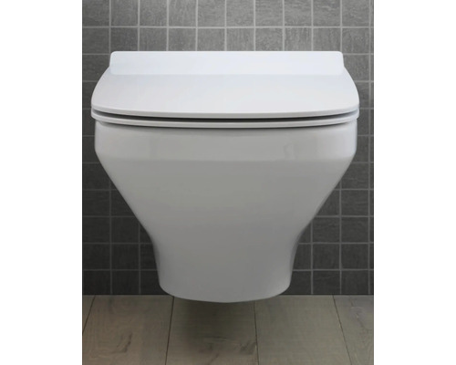 WC suspendu avec couvercle fermé devant un mur carrelé gris