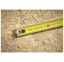 Mètre ruban enrouleur jaune sur une surface en bois