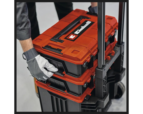Personne ouvrant un chariot de coffre à outils Einhell avec plusieurs boîtes