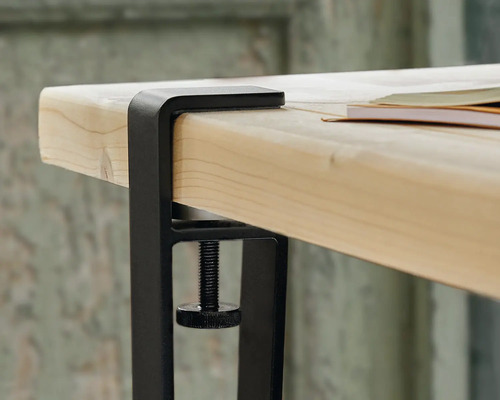 Vue détaillée d'un support de table avec serre-joint sur un plateau de table.