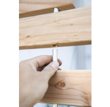 Vue détaillée d'une construction en bois avec une main tenant une tige métallique