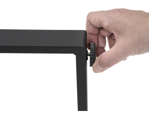 Une seule main actionne un pied de table noir pour le réglage en hauteur.