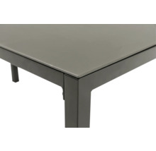 Vue détaillée d'une table de jardin avec plateau en verre et structure en métal.