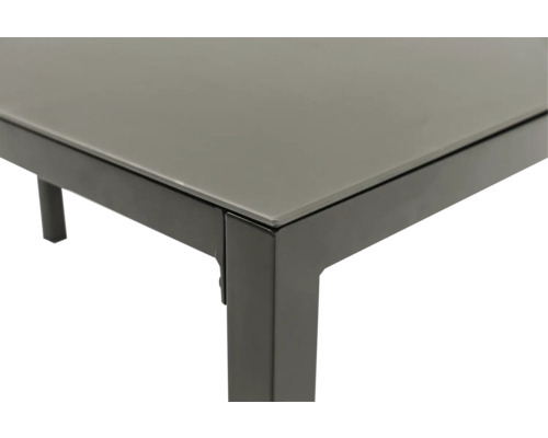 Vue détaillée d'une table de jardin avec plateau en verre et structure en métal.