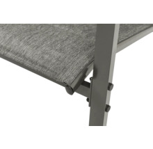 Gros plan d'un banc de jardin avec assise en textile et structure en métal.