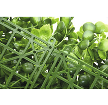 Vue détaillée d'un panneau de plantes artificielles avec des feuilles vertes et une grille en plastique