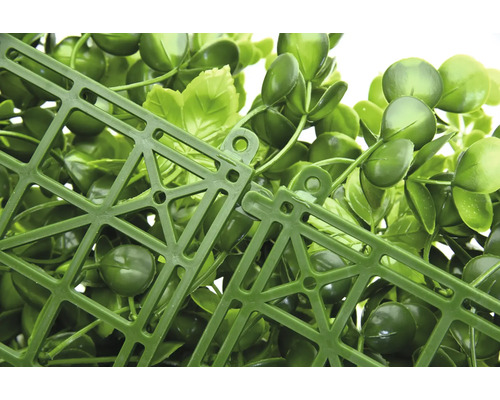 Vue détaillée d'un panneau de plantes artificielles avec des feuilles vertes et une grille en plastique