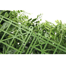 Gros plan d'une haie artificielle avec des feuilles vertes et un treillis en plastique