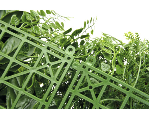 Gros plan d'une haie artificielle avec des feuilles vertes et un treillis en plastique