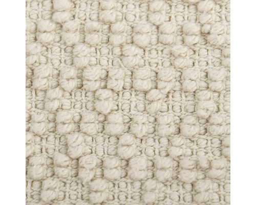 Gros plan d'un tapis beige à structure à picots