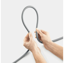 Eine graue Schlauchleitung wird von zwei Händen gehalten.