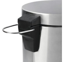 Vue détaillée du couvercle d'une poubelle à pédale avec mécanisme de pédale en métal.