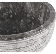 Gros plan d'un pot à fleurs en pierre grise avec une surface rainurée.