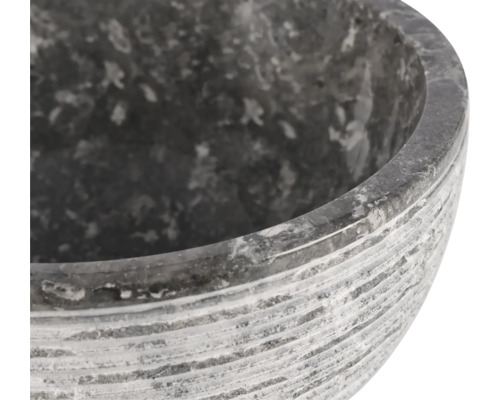 Gros plan d'un pot à fleurs en pierre grise avec une surface rainurée.