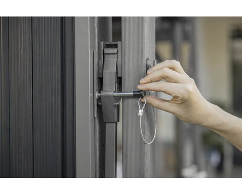 Detailansicht eines Tors mit einem Verschlussmechanismus und einer Person, die diesen betätigt