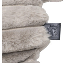 Gros plan d'un coussin en peluche avec le label de créateur Designed by Lotte