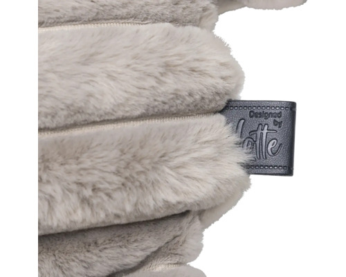 Gros plan d'un coussin en peluche avec le label de créateur Designed by Lotte
