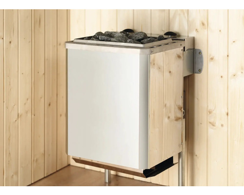 Poêle de sauna mural avec pierres, façade en acier inoxydable et paroi latérale en bois dans un sauna lumineux.