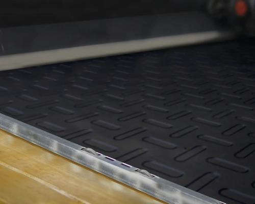 Schwarze Antirutschmatte mit Riffelblechmuster im Laderaum eines Fahrzeugs.