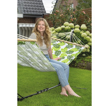 Femme se détend dans un hamac à motifs de feuilles dans le jardin