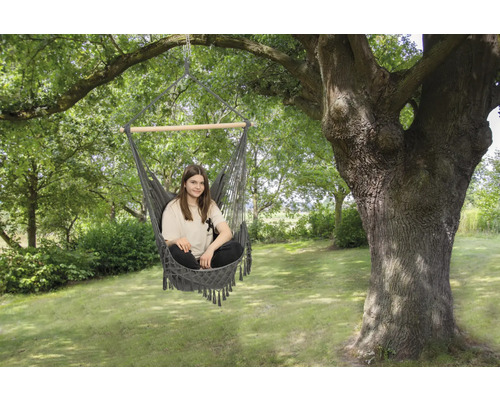 Femme assise dans un hamac dans le jardin sous un arbre