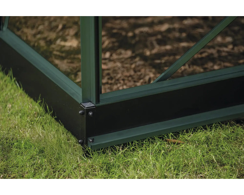 Detailansicht des Fundaments eines Gewächshauses auf einer Rasenfläche.