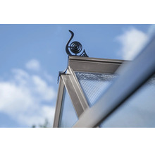 Detailansicht eines Gewächshauses mit dekorativer Spitze vor blauem Himmel