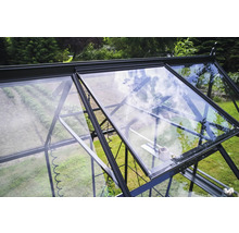 Vue détaillée d'une serre avec une fenêtre ouverte pour la ventilation