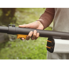 Une personne tient un souffleur de feuilles dans sa main.