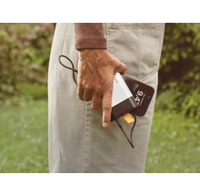 Eine Person hält ein Mobiltelefon und eine Powerbank.