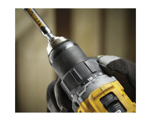 Nahaufnahme einer Bohrmaschine mit eingesetztem Bohrer, gehalten von einer Hand mit Arbeitshandschuh