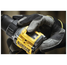 Eine Person mit Arbeitshandschuhen hält einen Dewalt Akku-Bohrschrauber.