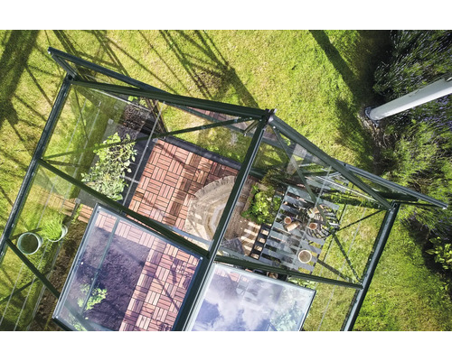 Vue de dessus d'une serre avec des plantes et des outils de jardinage sur une pelouse