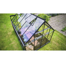 Serre avec plantes et outils de jardin dans le jardin