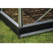 Vue détaillée de la fondation d'une serre sur l'herbe