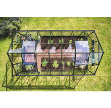 Vue de dessus d'une serre avec des plantes et un sol carrelé dans le jardin.