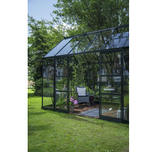 Serre avec plantes, chaise et accessoires de jardin dans le jardin