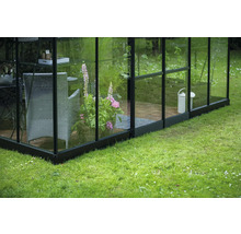 Serre avec pot de fleurs, chaise et arrosoir dans le jardin