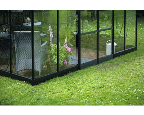 Serre avec pot de fleurs, chaise et arrosoir dans le jardin