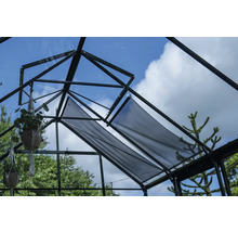 Vue intérieure d'une serre avec système d'ombrage et plantes suspendues