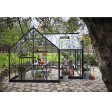 Serre avec plantes et groupe de tables dans le jardin