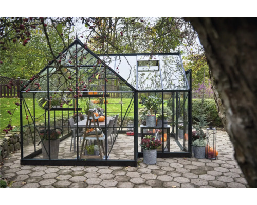 Serre avec plantes et groupe de tables dans le jardin