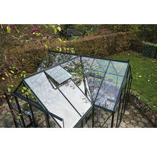 Une serre avec une fenêtre ouverte dans un jardin.