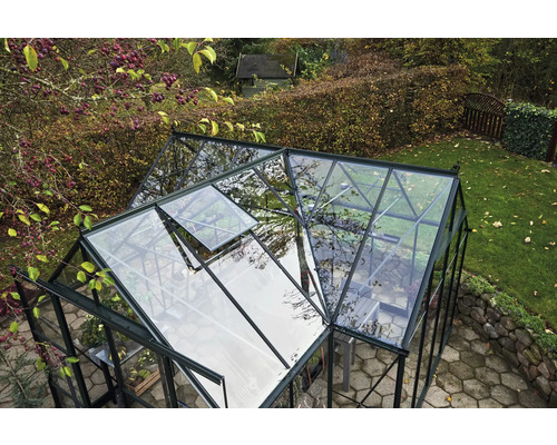 Une serre avec une fenêtre ouverte dans un jardin.