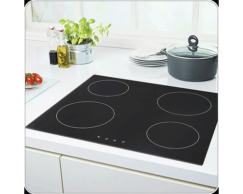 Plaque vitrocéramique noire avec quatre zones de cuisson sur un plan de travail blanc