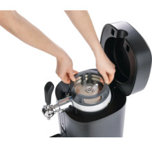 Bierzapfanlage mit eingesetztem Fass und Bedienung durch Hände