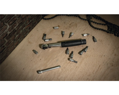 Clé dynamométrique avec douilles et chaînes sur une surface en bois