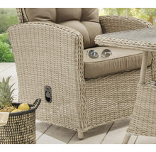 Nahaufnahme eines Korbsessels mit Kissen und einem kleinen Tisch