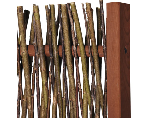 Detailansicht eines Zaunelements aus naturbelassenen Ästen und einem Holzpfosten