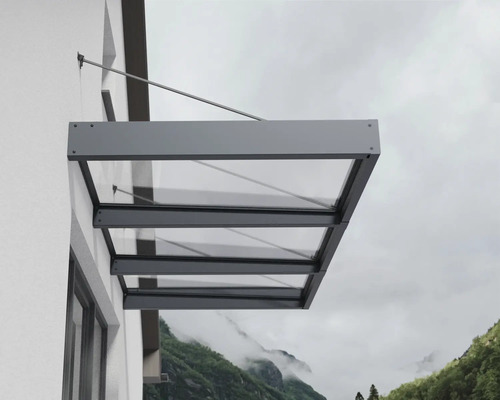 Marquise moderne en verre avec cadre en aluminium anthracite, fixée au mur extérieur par des tirants.